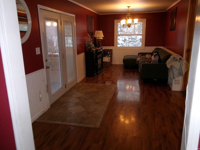 hallway with a chandelier, crown molding, and dark hardwood / wood-style floors