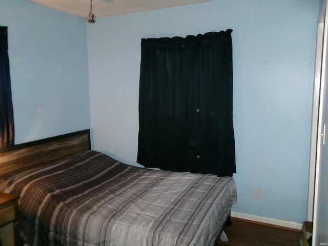 bedroom with dark hardwood / wood-style floors