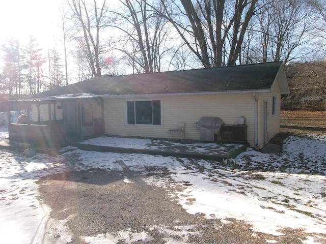 view of snow covered back of property