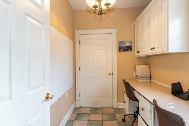 home office with an inviting chandelier, built in desk, and light tile patterned flooring