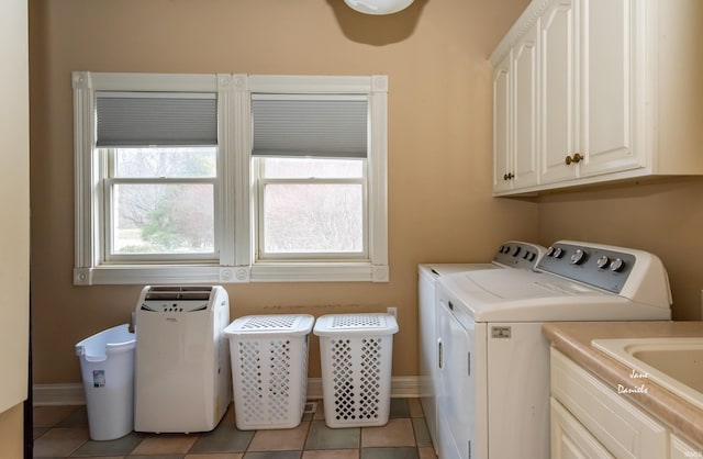 laundry area with cabinets, separate washer and dryer, light tile patterned floors, and sink