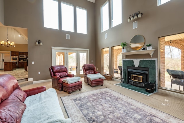 living room featuring french doors, a towering ceiling, a notable chandelier, and carpet flooring