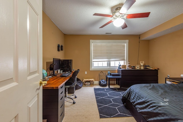 carpeted bedroom featuring ceiling fan and a textured ceiling