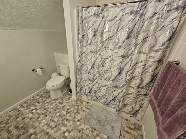 bathroom with toilet, a shower with shower curtain, a textured ceiling, and lofted ceiling