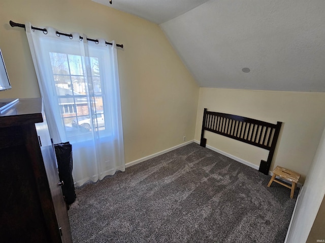 bonus room featuring lofted ceiling and dark carpet