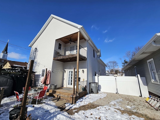 snow covered property featuring ceiling fan and a balcony