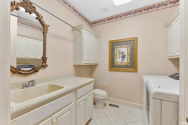 bathroom featuring washing machine and dryer, toilet, tile patterned floors, and vanity