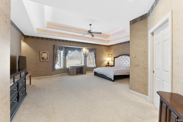 bedroom with ceiling fan, a raised ceiling, and carpet floors