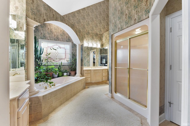 bathroom featuring independent shower and bath, vanity, and decorative columns