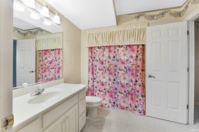 bathroom featuring toilet, vanity, and curtained shower