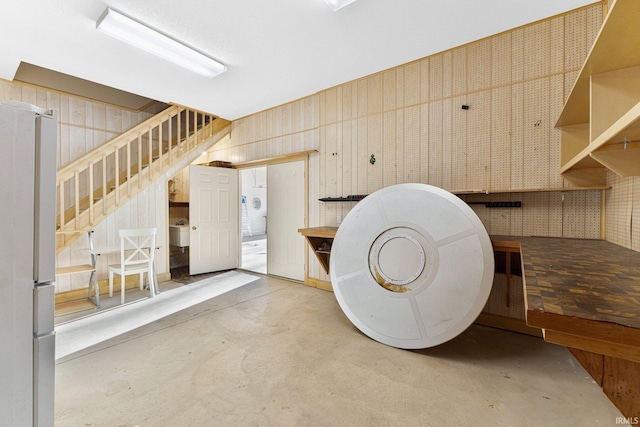 interior space with concrete floors, wooden walls, and a workshop area