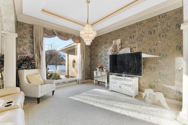 living room featuring a raised ceiling, carpet, an inviting chandelier, and decorative columns