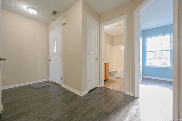 entryway with a textured ceiling and dark wood-type flooring