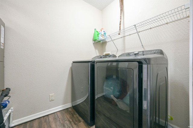 laundry room with a textured ceiling, dark wood-type flooring, and independent washer and dryer