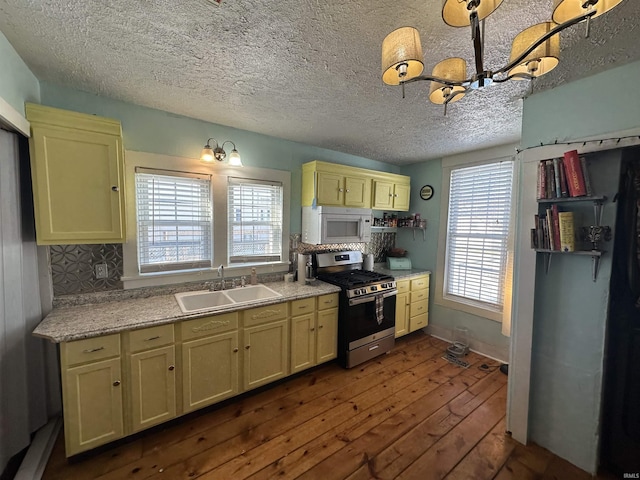 kitchen with decorative backsplash, dark wood-type flooring, sink, and gas range