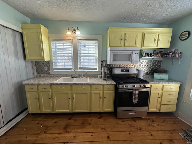 kitchen with a textured ceiling, stainless steel gas range, tasteful backsplash, sink, and dark hardwood / wood-style floors