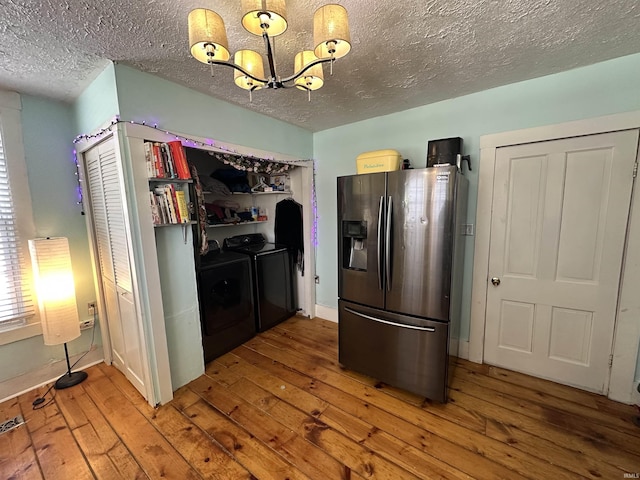 kitchen with stainless steel refrigerator with ice dispenser, hardwood / wood-style floors, a chandelier, and washing machine and clothes dryer