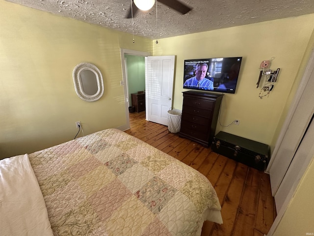 bedroom with ceiling fan, wood-type flooring, and a textured ceiling