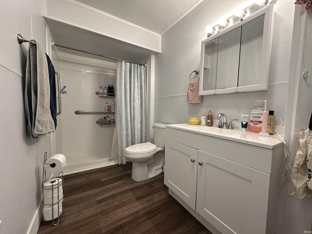 bathroom featuring toilet, hardwood / wood-style flooring, walk in shower, crown molding, and vanity