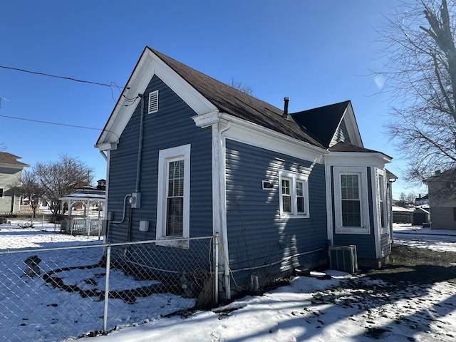 snow covered property with central AC