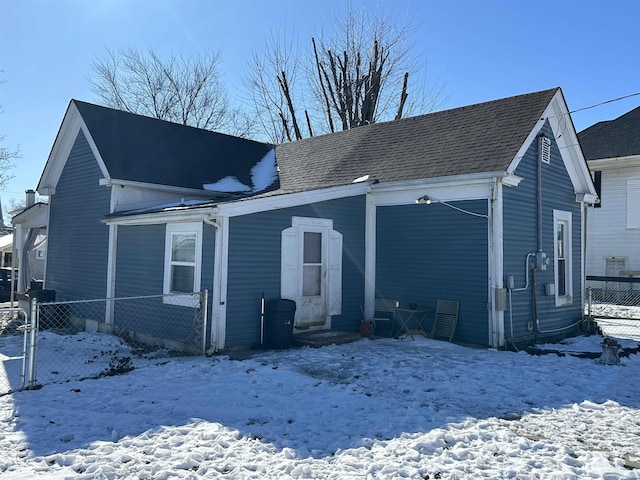 view of snow covered rear of property