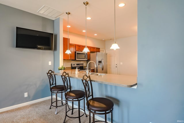 kitchen with light colored carpet, sink, a kitchen breakfast bar, and stainless steel appliances