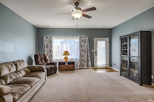 carpeted living room with ceiling fan