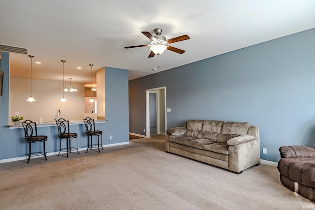 carpeted living room featuring ceiling fan with notable chandelier