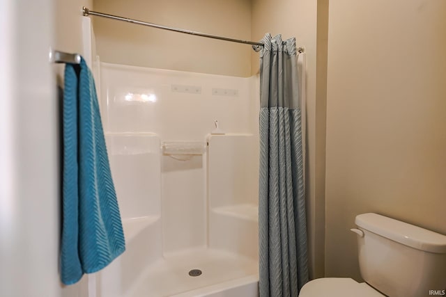 bathroom featuring toilet and a shower with curtain