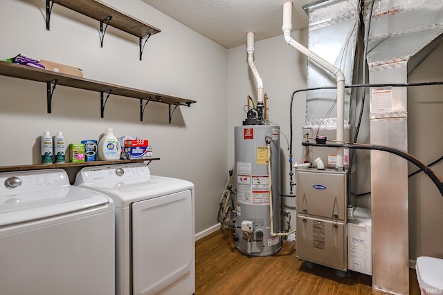 laundry room featuring water heater, washer and clothes dryer, dark wood-type flooring, heating unit, and a textured ceiling