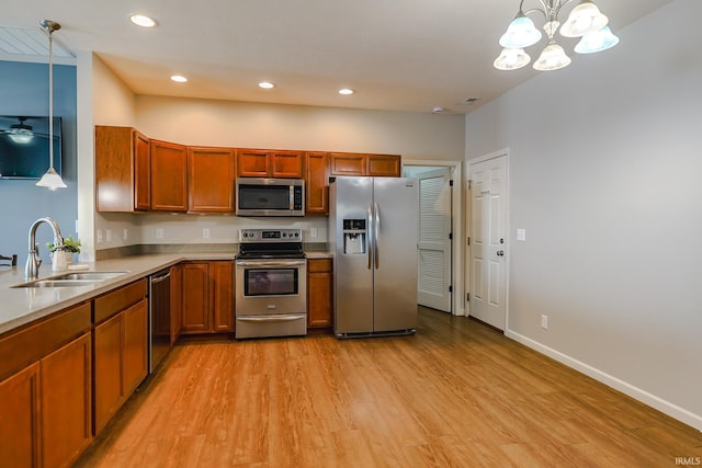 kitchen featuring decorative light fixtures, ceiling fan, sink, light hardwood / wood-style flooring, and stainless steel appliances