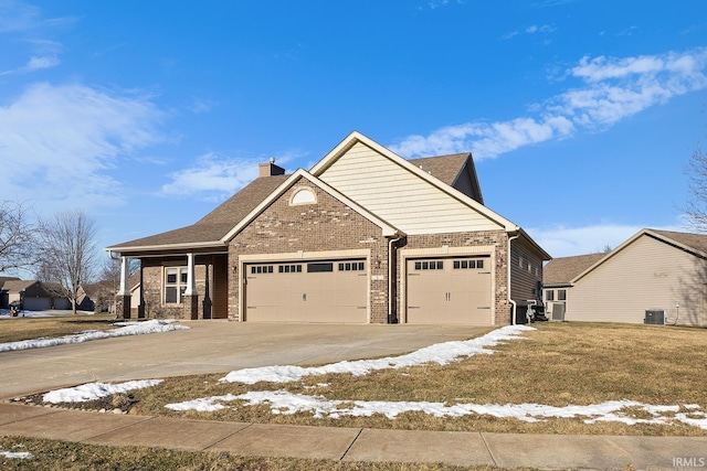 craftsman-style home with a garage, a yard, and central air condition unit