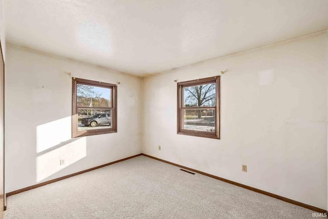 carpeted spare room with a healthy amount of sunlight