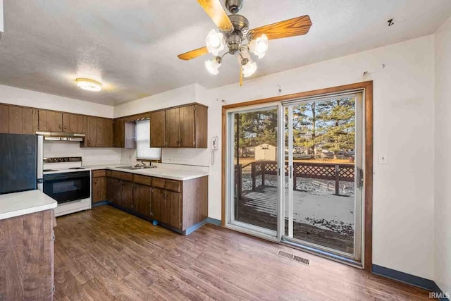 kitchen with white electric range, dark hardwood / wood-style flooring, sink, refrigerator, and ceiling fan