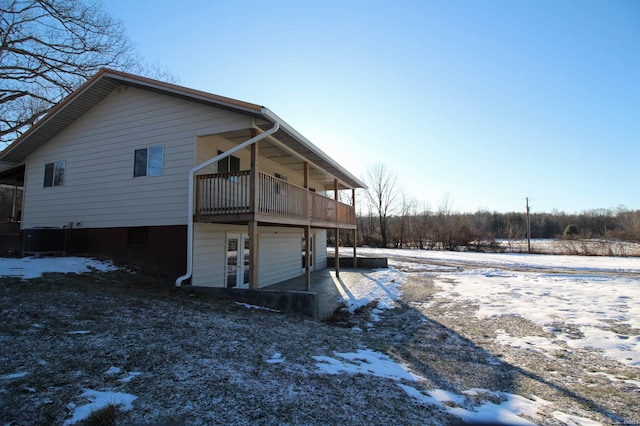 view of snowy exterior with cooling unit and a balcony