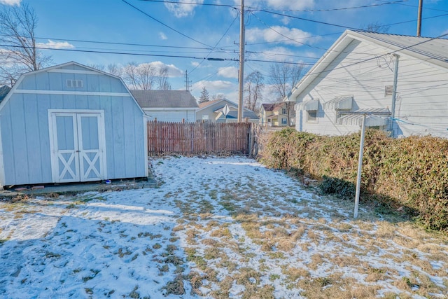 yard covered in snow featuring a storage shed