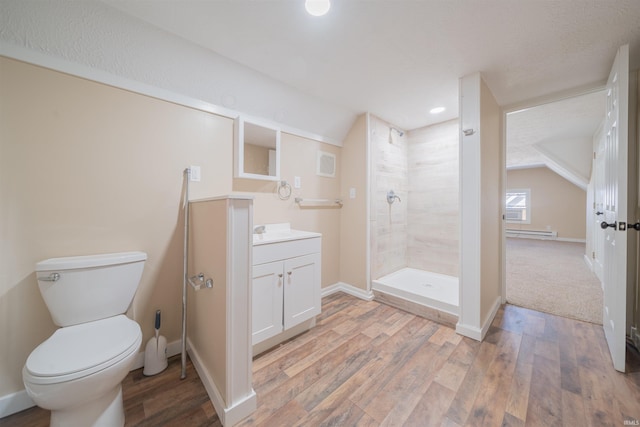 bathroom with lofted ceiling, vanity, toilet, hardwood / wood-style flooring, and tiled shower