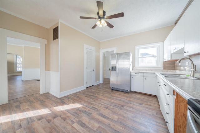 kitchen featuring hardwood / wood-style floors, white cabinets, stainless steel appliances, sink, and crown molding