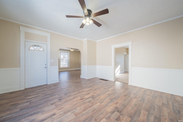 interior space featuring ceiling fan, wood-type flooring, and crown molding