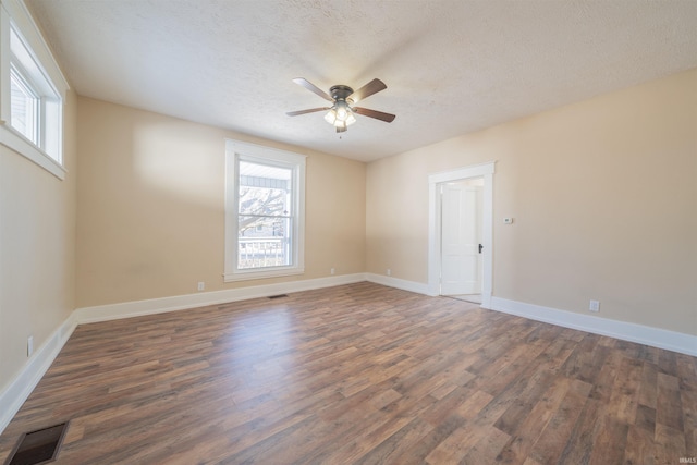 unfurnished room with ceiling fan, a textured ceiling, and dark hardwood / wood-style flooring