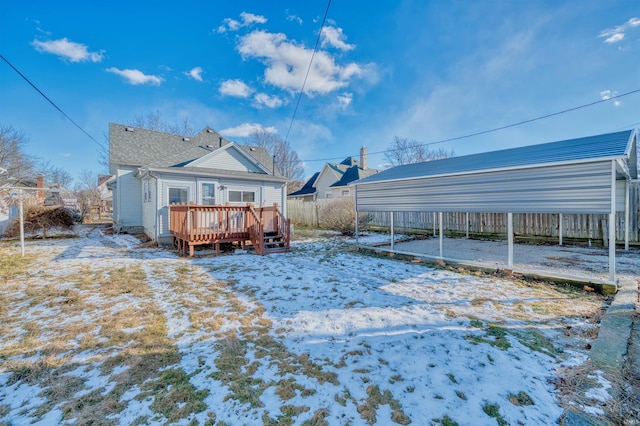 snow covered back of property with a deck