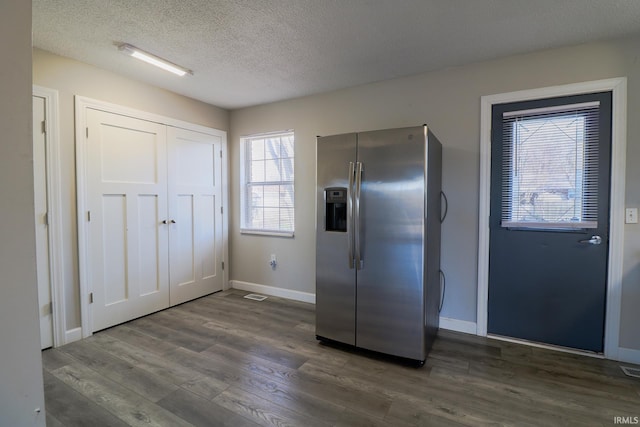 kitchen with stainless steel fridge with ice dispenser, dark hardwood / wood-style flooring, and a textured ceiling