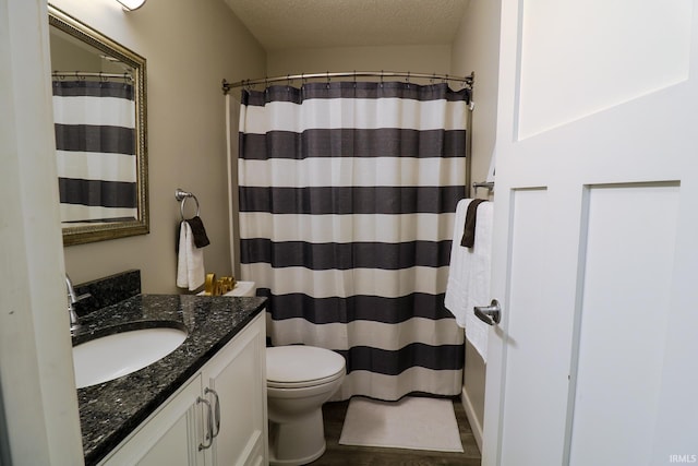 bathroom featuring toilet, vanity, a shower with curtain, and a textured ceiling