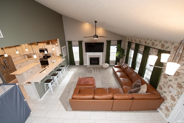 living room with ceiling fan and high vaulted ceiling