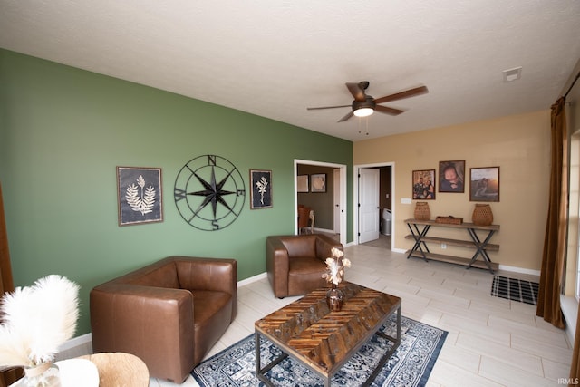 living room featuring a textured ceiling and ceiling fan