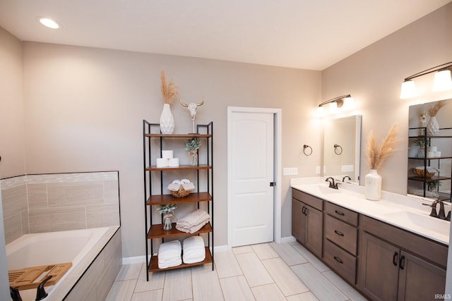 bathroom with tiled tub and vanity