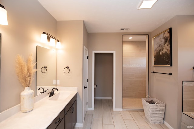 bathroom with vanity and tiled shower