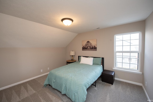 carpeted bedroom with vaulted ceiling and multiple windows