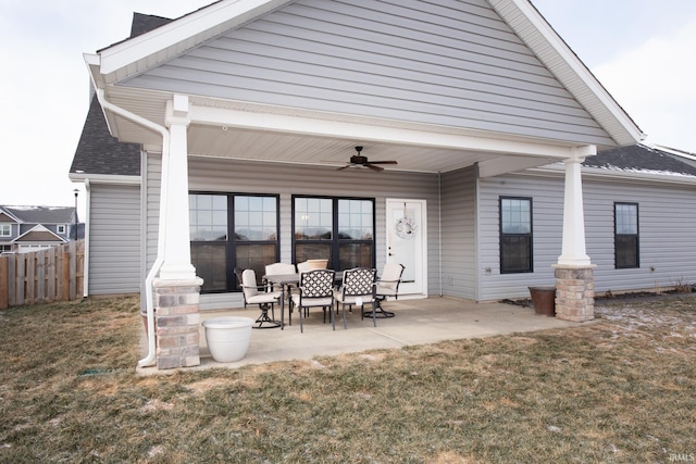 rear view of house with ceiling fan, a yard, and a patio