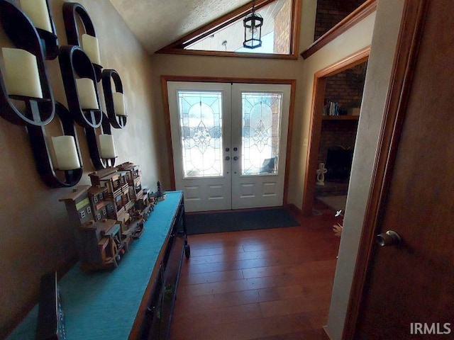 doorway to outside with lofted ceiling, french doors, dark hardwood / wood-style flooring, and a textured ceiling